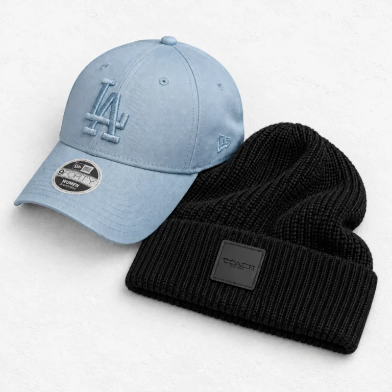 New Era New York Yankees and Coach Knit Beanie With Rubber Patch arranged on a white cement background