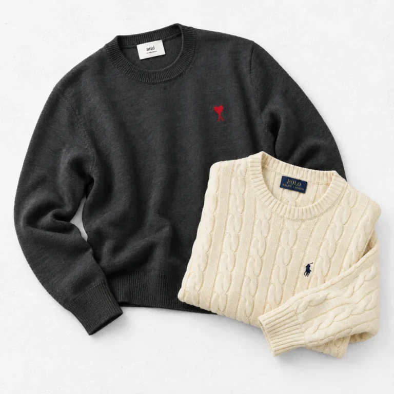Ami paris Red Ami de Coeur Crew Neck Sweater and Ralph Lauren Cable-Knit Cotton Sweater arranged on a white cement background
