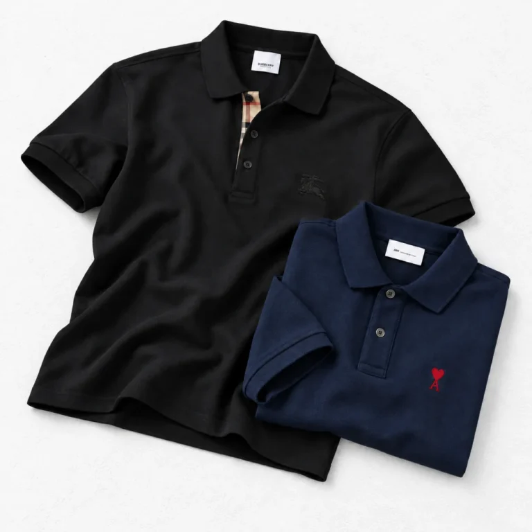 Burberry Classic Cotton Polo Shirt and AMI Paris Friend of Heart polo shirt arranged on a white cement background