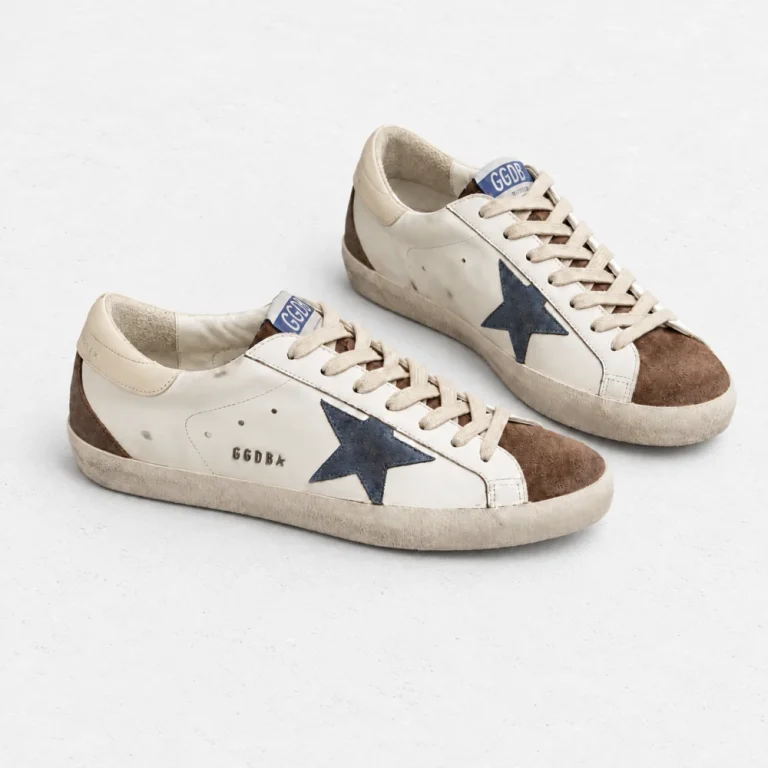 Golden Goose leather Super-Star Sneakers arranged on a white cement background