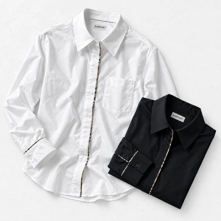 Burberry Check Trim Shirt and Burberry Check Trim Shirt arranged on a white cement background